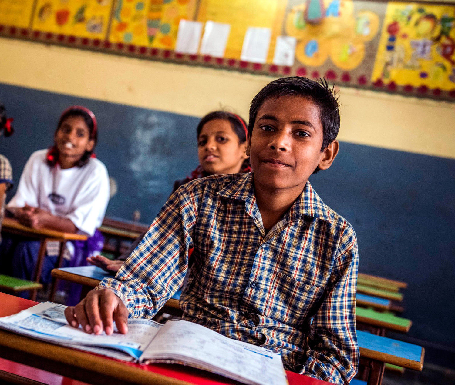 Moshin at his desk in a classroom in India